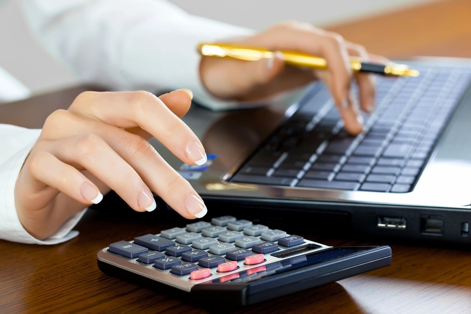 Making Tax Digital, someone calculating their MTD return, only hands, calculator and laptop in the image